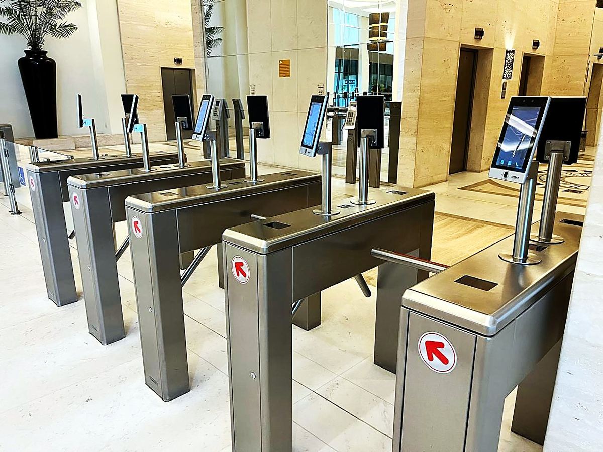 Suporte em inox para leitor facial, instalado sobre catraca